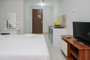 Televisyen dan/atau pusat hiburan di Fully Furnished Studio with Comfort Design Majestic Point Serpong Apartment By Travelio