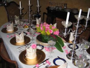 a table with a white table cloth with plates and flowers at La Perla Hotel Boutique B&B in Guadalajara