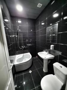 a bathroom with a sink and a tub and a toilet at Chveni sakhli in Tbilisi City