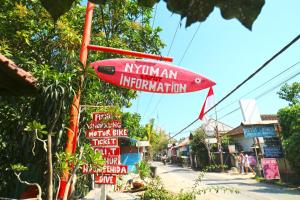 un cartel que lee inmigración myanmar colgando sobre una calle en Nyoman Guesthouse and Grill en Nusa Lembongan