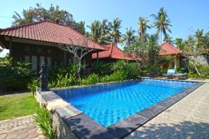 a swimming pool in front of a house at Nyoman Guesthouse and Grill in Nusa Lembongan