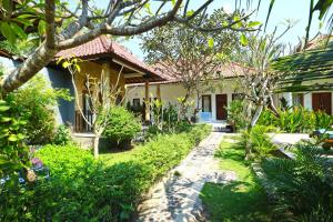 a house with a garden in front of it at Nyoman Guesthouse and Grill in Nusa Lembongan