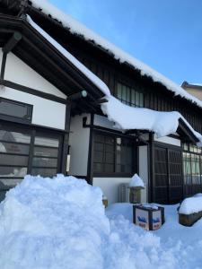 una pila de nieve frente a un edificio en B&B MIKAWA - Kanazawa Fish Harbour, en Kanazawa
