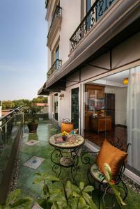 a patio with a table and chairs on a balcony at Hanoi Pearl Hotel in Hanoi