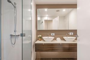 a bathroom with two sinks and a shower at Saltwater Suites - 1,2 & 3 Bed Waterfront Apartments in Darwin