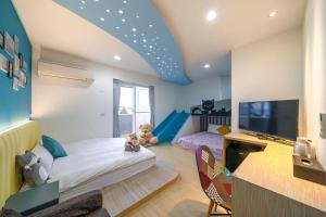 a bedroom with a bed and a tv in a room at Playful Paradise in Dongshan