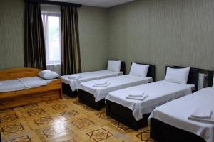 a room with three beds and a window at Chveni sakhli in Tbilisi City
