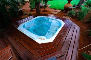 a hot tub on a deck with a tree in it at Mhulu Signature Boutique Hotel in Pretoria