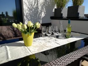 stół z okularami i wazon z kwiatami w obiekcie PENTHOUSE Griemann 1 mit Infrarotkabine und eigener Dachterrasse für max 4 Personen w mieście Illmitz