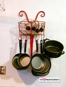 a group of frying pans and a rack of pans at Departamento completo a pasos de Santa Lucia mty in Monterrey