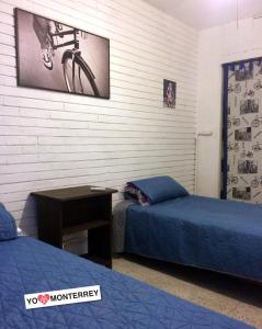 una habitación con 2 camas y una bicicleta en la pared en Departamento completo a pasos de Santa Lucia mty, en Monterrey