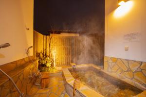 y baño con bañera y ducha de vapor. en Yufuin Matsuri-an Nagomiya, en Yufu