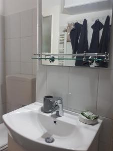 y baño con lavabo blanco y espejo. en Cocooning in a Lovely Mountain suite - Two, en Azuga