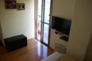 a living room with a flat screen tv on the wall at Youran B&B in Jiufen