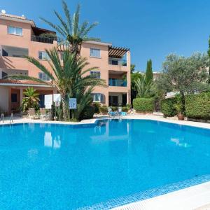a large blue swimming pool in front of a building at Tala Hills Sea view apartment in Paphos