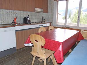a kitchen with a table and chairs and a kitchen with a counter at Ferienwohnung Silberdistel in Adelboden
