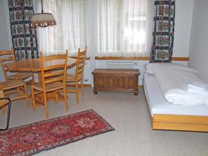 1 dormitorio con 1 cama, mesa y sillas en Ferienwohnung Silberdistel, en Adelboden