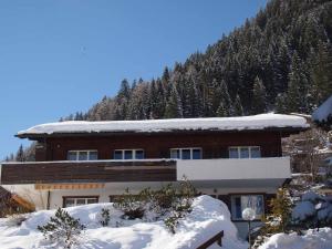 a building covered in snow with a mountain at Ferienwohnung Silberdistel in Adelboden