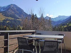 una mesa y sillas en un balcón con montañas en Ferienwohnung Silberdistel, en Adelboden