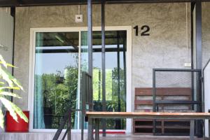 a glass door of a building with a bench outside at Smile Box Coffee & Resort in Ban Nong Hin