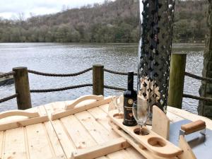 a table with a bottle of wine and a glass at Horton Lodge Boathouse in Leek