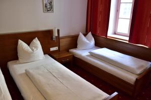 a hotel room with two beds and a window at Hotel Krone in Brunico