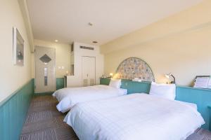 two beds in a room with blue and white at Tabist Kinugawa Park Cottage in Nikko