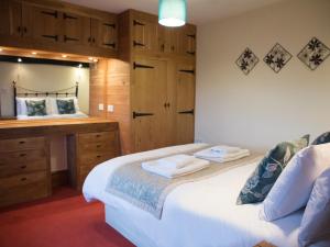 a bedroom with a bed and a dresser and a desk at Yew Tree Cottage in Great Malvern