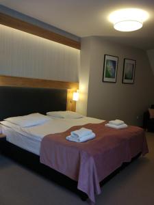 een hotelkamer met een bed met handdoeken erop bij Bulwary Biznes in Mielec