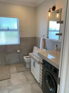 een badkamer met een wasmachine en een wastafel bij Pont de Val - La Rivière Apartments in Parys