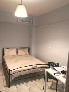 1 dormitorio con cama, mesa y escritorio en House in the center of Piraeus next to the port and the metro!!, en Pireo