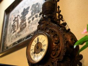a clock with a statue on it next to a picture at Oyado Yamakyu in Takayama