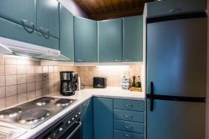 eine Küche mit blauen Schränken und einem Herd mit Backofen in der Unterkunft Riekko Chalet in Rovaniemi