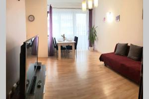 a living room with a red couch and a table at Luxury KINGS RESIDENCE 50m2 2 pok. Downtown Dobrego Pasterza PIĘKNY in Kraków