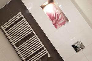 a mirror in a bathroom with a pink flower on the wall at Luxury KINGS RESIDENCE 50m2 2 pok. Downtown Dobrego Pasterza PIĘKNY in Kraków +33 photos