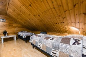 2 Betten in einem Zimmer mit Holzdecke in der Unterkunft Riekko Chalet in Rovaniemi