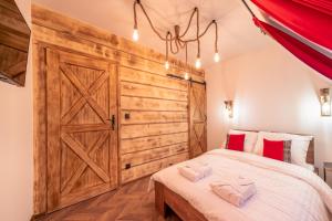 a bedroom with a large wooden door and a bed at Luxury Houses & Apartments Zaliński in Zakopane