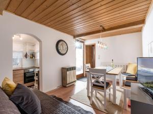 cocina y sala de estar con mesa y reloj en Grabner Riedleiten Bienenhaus, en Oberaudorf