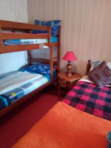 1 Schlafzimmer mit 2 Etagenbetten und einem Tisch mit einer Lampe in der Unterkunft Au fruit delicieux in La Plaine des Cafres