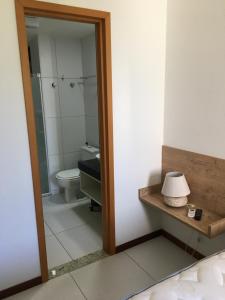 La salle de bains est pourvue de toilettes et d'une douche en verre. dans l'établissement Residence Iloa Resort, à Barra de São Miguel