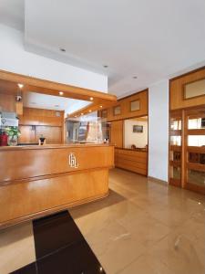 a large room with a kitchen with wooden cabinets at Gran Lourdes Hotel by CPH in Villa Carlos Paz