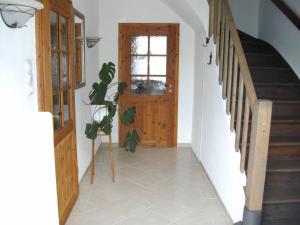 einen Flur mit Holztür und Pflanze in der Unterkunft Frey - Ferienhaus über zwei Etagen mit Terrasse in Eggebek