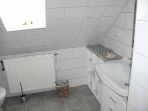 a white bathroom with a sink and a toilet at Ferienhaus Frey in Eggebek