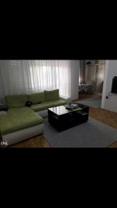 sala de estar con sofá verde y mesa de centro en Dan i noc, en Banja Luka