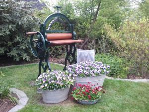 ławka siedząca w trawie z dwoma wiadrami kwiatów w obiekcie XXS Appartement Junghans w mieście Silberstedt