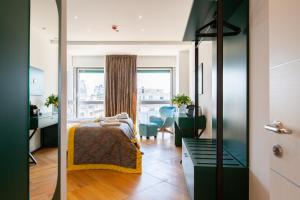 a bedroom with a bed and a desk and a window at Missori Suites in Milan