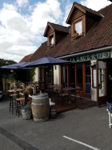 un restaurante con mesas, sillas y sombrillas en La Taverne en Buire-le-Sec