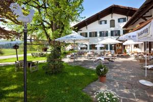 eine Terrasse mit Tischen und Sonnenschirmen vor einem Gebäude in der Unterkunft Landhotel Gockelwirt in Eisenberg