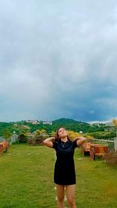 a woman standing in a field with her hands on her head at 8 JOAQUIN'S Place WIFI Free! in Antipolo