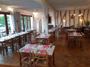 una sala da pranzo con molti tavoli e sedie di La Taverne a Buire-le-Sec